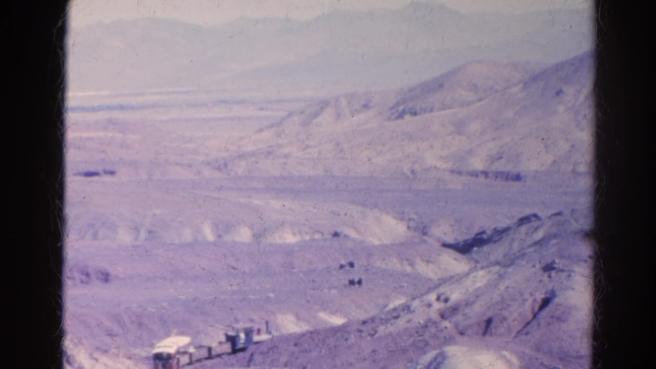 End frame of the 1966 8mm clip with a small train or rail vehicle at the lower edge, set against layered desert hills near Silver Lake, California.