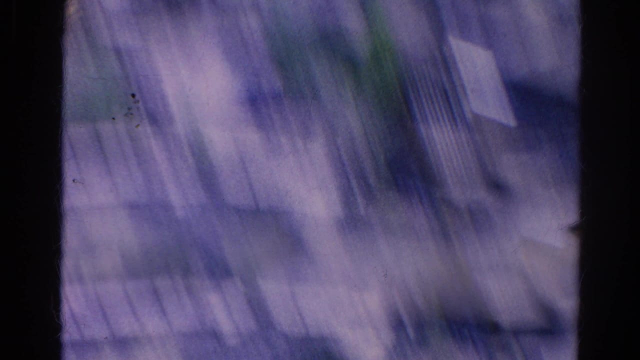 Blurred 1966 8mm motion frame from the Silver Lake landscape sequence, with streaked shapes and film grain.