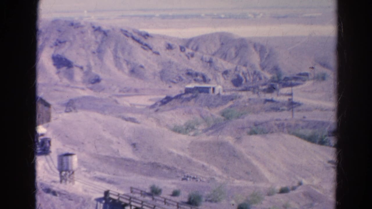 1966 Silver Lake desert valley view with mining or rail infrastructure, including tracks, a water tower, and a wooden trestle bridge.