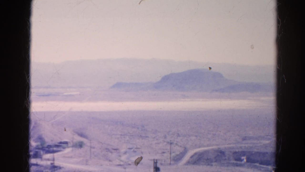 1966 Silver Lake, California 8mm frame looking across a hazy desert valley with a road, utility poles, and distant ridge.