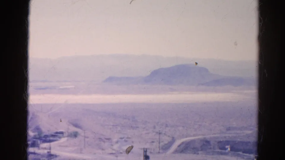1966 Silver Lake, California 8mm frame looking across a hazy desert valley with a road, utility poles, and distant ridge.
