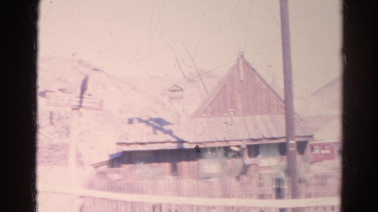 1966 Silver Lake 8mm frame with a weathered building, central utility pole, small sign, fencing, and arid hills.