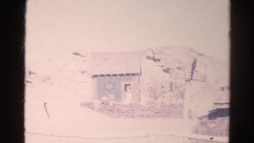 Faded 1966 8mm frame from Silver Lake showing a pale exterior view with dark film edges and low visible detail.