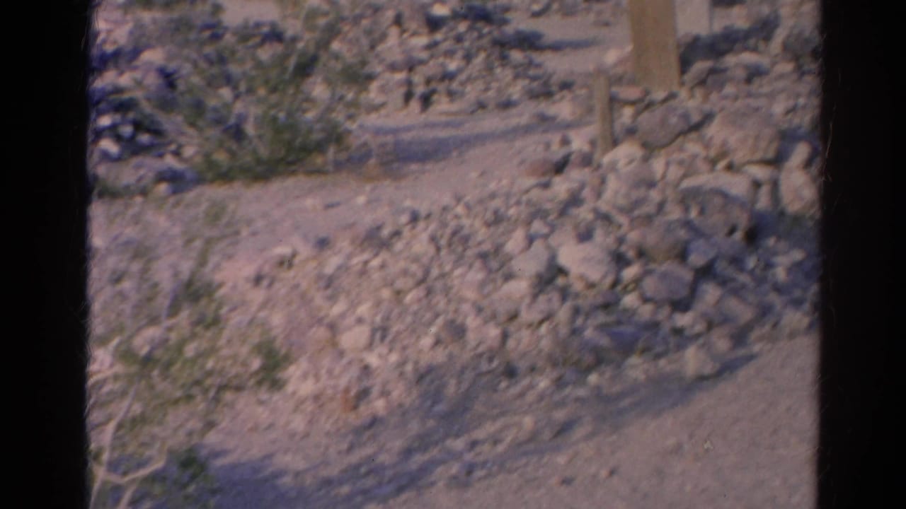 1966 Silver Lake footage appears to show rocky desert terrain with scattered stones, low shrubs, and a post in a dry wash-like area.