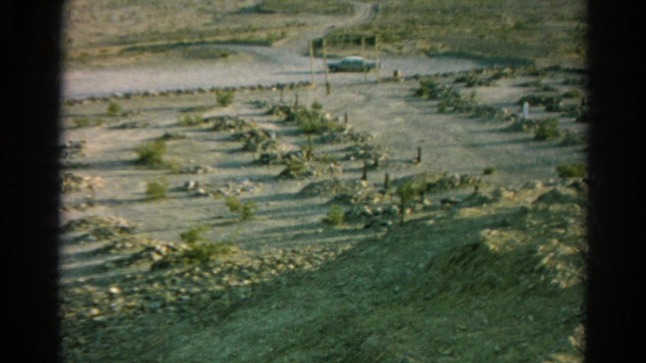 Silver Lake, California burial ground in 1966, showing scattered markers across dry ground with a roadside car in the distance.