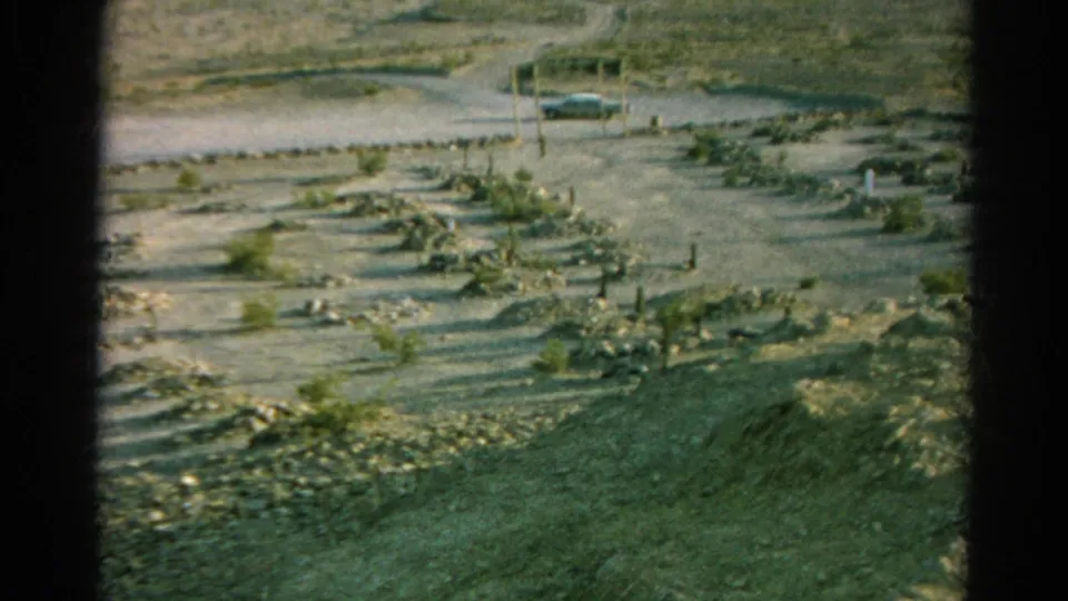 Silver Lake, California burial ground in 1966, showing scattered markers across dry ground with a roadside car in the distance.