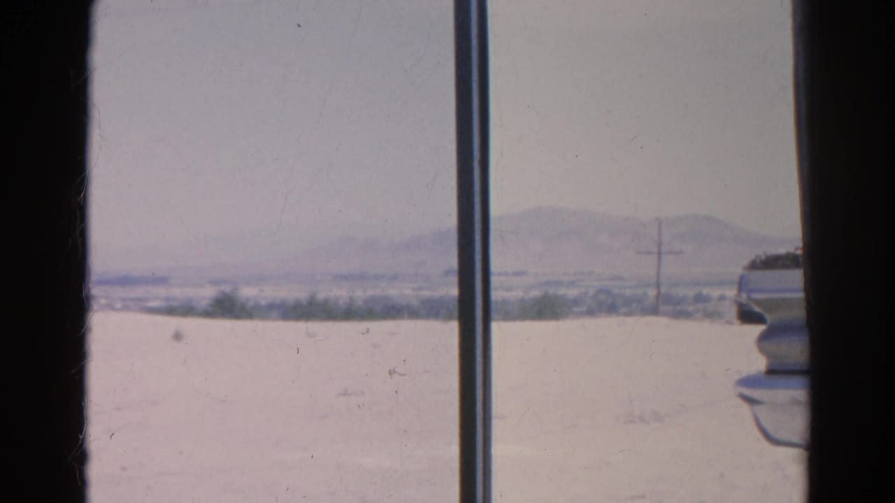 1966 Silver Lake, California view of pale dry ground, distant hills, sparse greenery, and a utility pole seen through window framing.