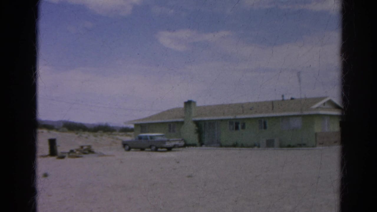 1966 Silver Lake frame showing the sedan parked in front of the pale green house as the camera pan brings more of the building into view.