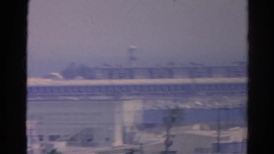 The final frame holds on hazy Silver Lake industrial structures, tower forms, and palms behind dark window edges.