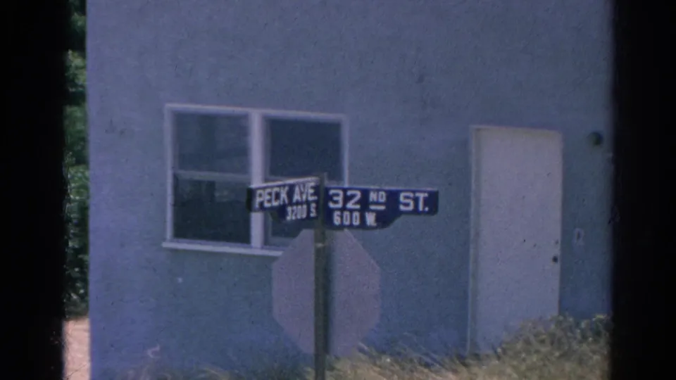 Silver Lake intersection marker for Peck Ave and 32nd St, seen through soft 8mm color and film-edge shadow.