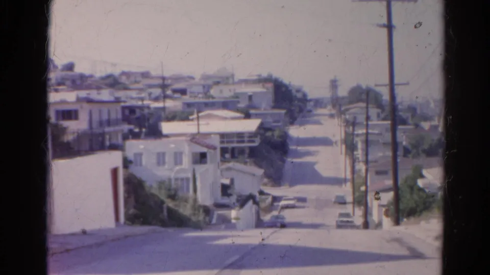 Silver Lake, California street view from 1966 showing hillside homes, parked cars, utility poles, and a quiet sunlit road.