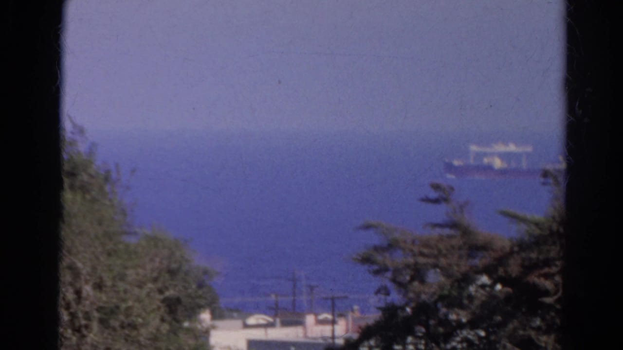 Final frame shows a distant ship on hazy blue water with foreground trees and shoreline structures, from the 1966 Silver Lake clip.