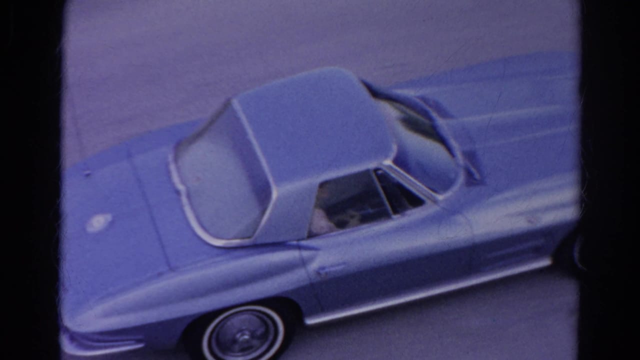 1966 Silver Lake home-movie frame showing a light blue classic sports car from an elevated angle, with film borders and soft 8mm color.
