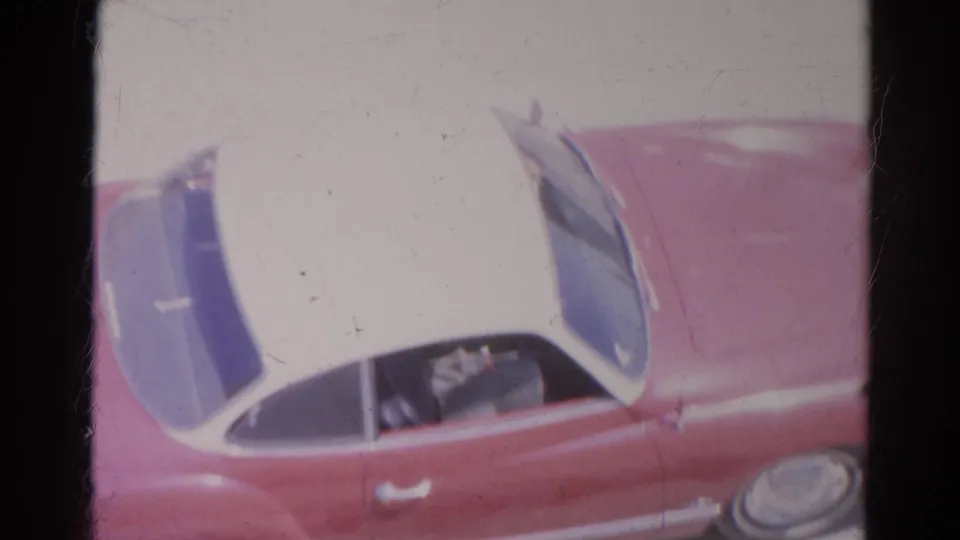 Close home-movie view of the red and white car in Silver Lake, with the side window and front fender partly visible.
