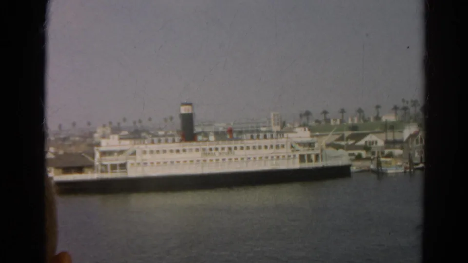 Reported 1966 California harbor view with a white passenger vessel, dark funnel, piers, and palm trees behind the waterfront.
