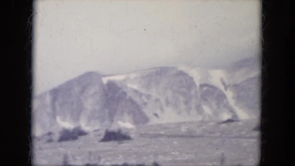 1966 South Dakota 8mm frame with distant pale mountain ridges seen through soft home-movie exposure.