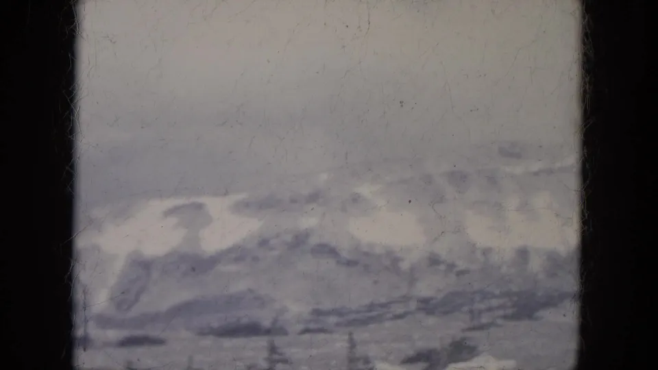 1966 South Dakota home-movie view of distant snowy hills and a pale winter sky, with visible film grain and frame edges.