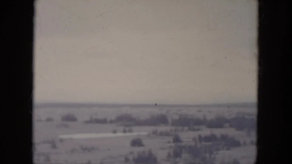 1966 South Dakota 8mm frame showing a hazy rural landscape with open fields and distant tree lines.