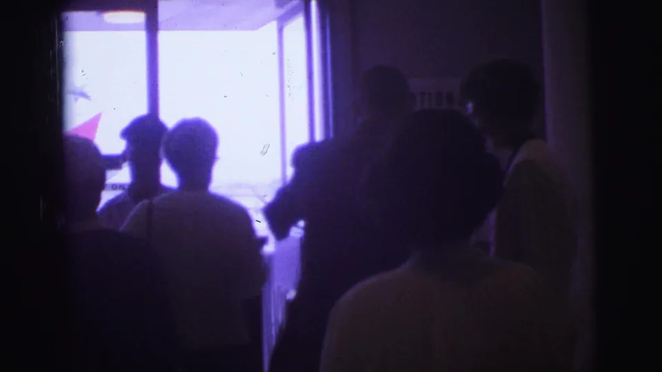 1967 Brazil terminal scene with travelers silhouetted in line near a bright doorway and partial airline signage.