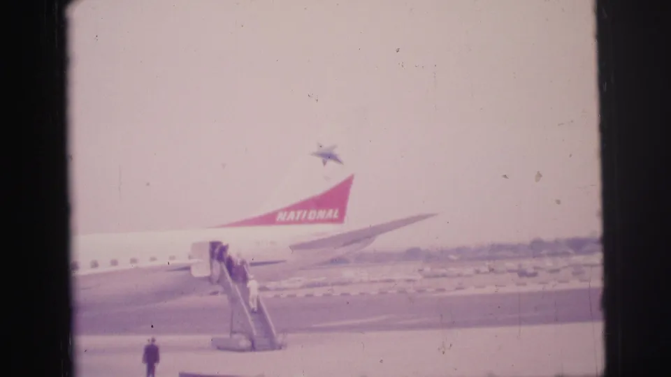 Soft 8mm frame from Brazil in 1967 showing open-apron boarding beside a National Airlines aircraft.