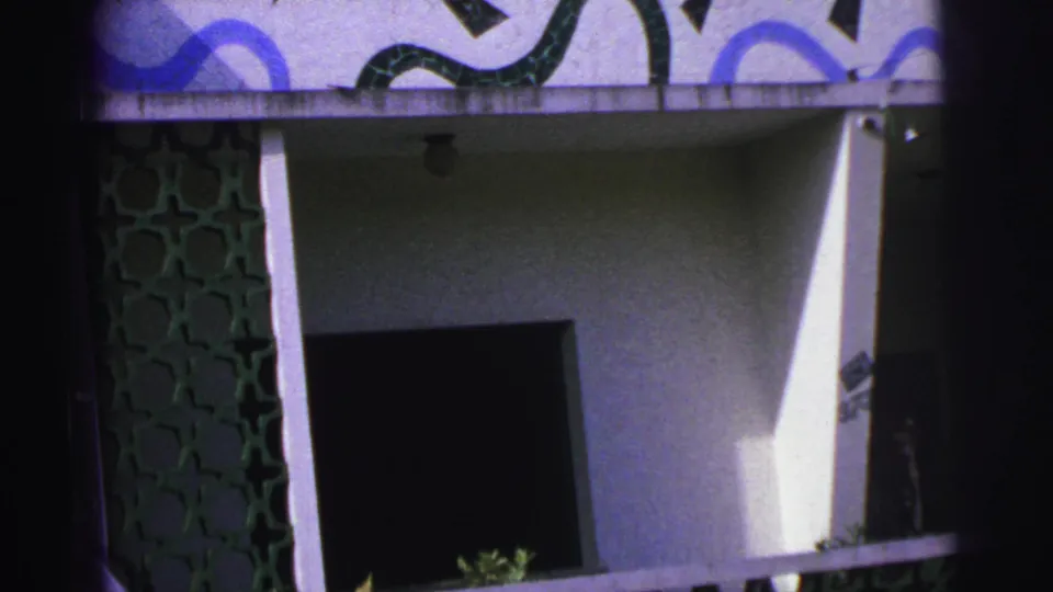 1967 Brazil frame of a modernist building entrance with green decorative lattice, white wall planes, and blue-black geometric facade art.