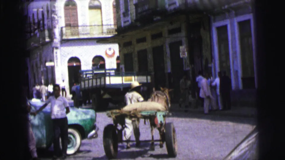 1967 Brazil street corner with pedestrians near a green car and a horse-drawn cart in the foreground.