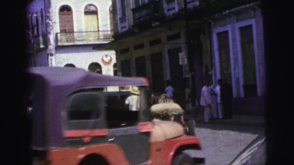 A red Jeep-style vehicle crosses the 1967 Brazil street view while a horse cart and pedestrians remain behind it.