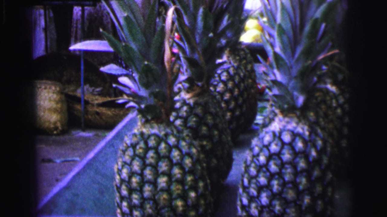 Close view of pineapples arranged on a market stall.