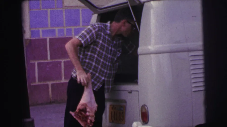 The 1967 Brazil home-movie frame shows the man holding raw meat beside the white van, with a plate and tail light visible.