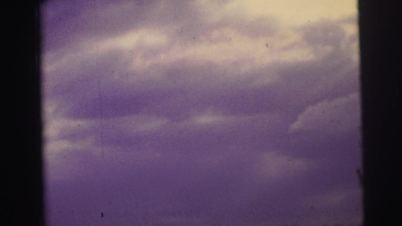 Purple clouded sky framed by dark vertical film edges.