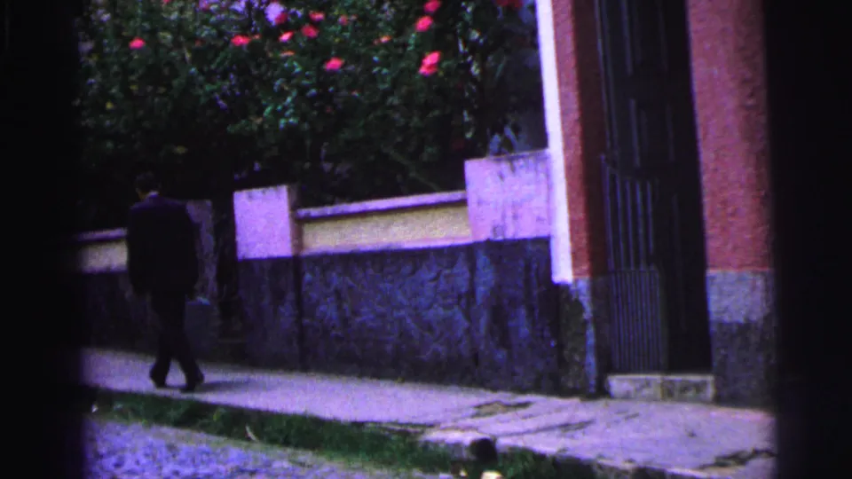 A dark-suited man with a briefcase walks near the left edge of the frame in this 1967 Brazil home-movie street view.