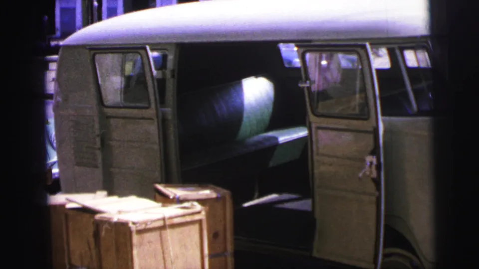 Open van at a Brazilian dock in 1967, with wooden crates in front and a large cylindrical load visible through the side opening.