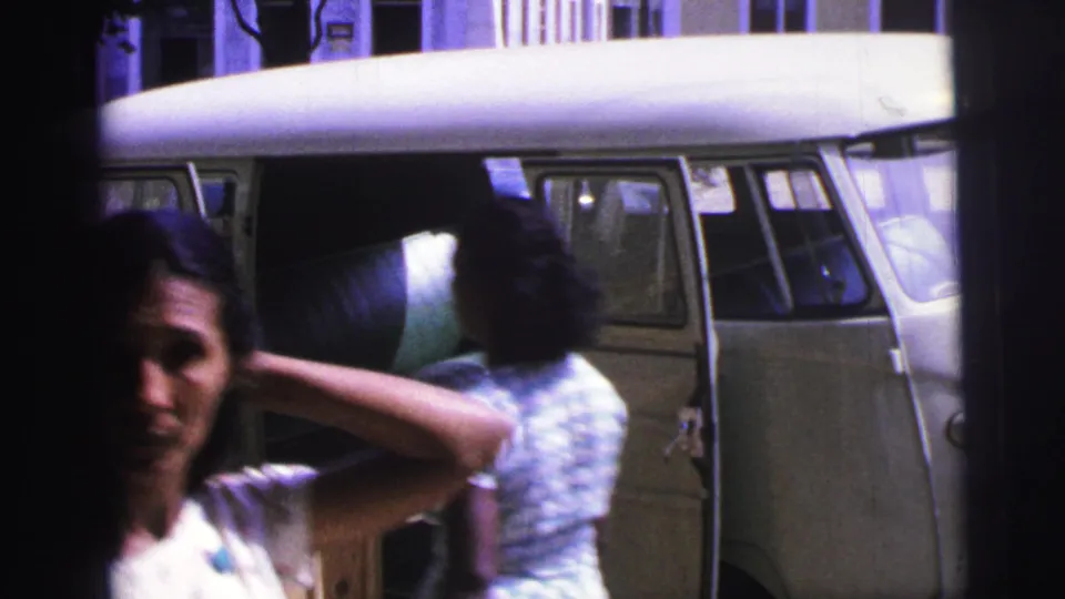1967 Brazil street frame with a woman in the foreground and a two-tone van behind her.