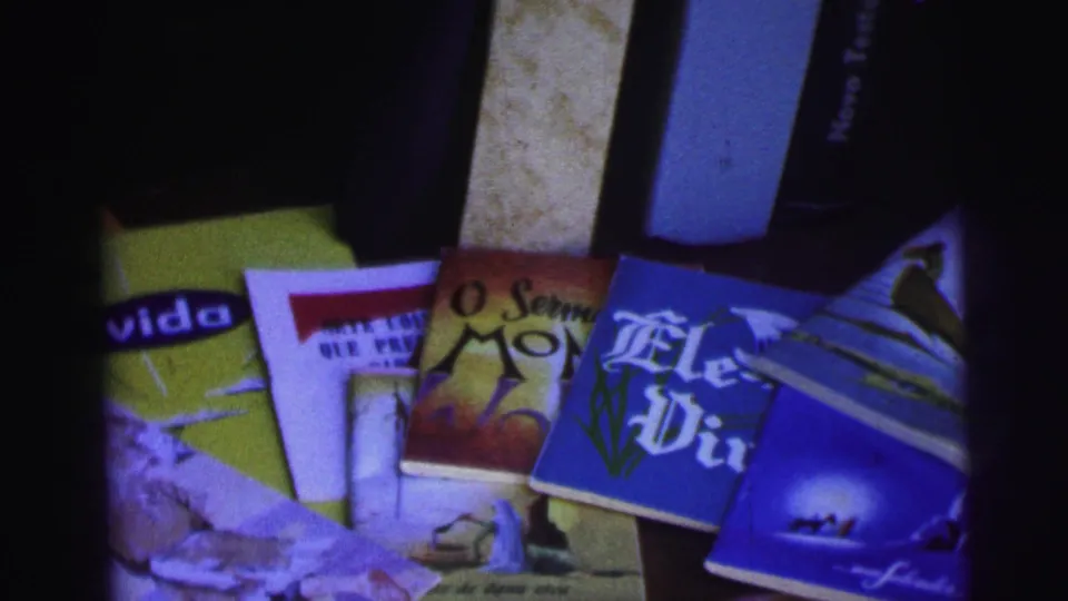 Soft 8mm frame from Brazil in 1967 showing fanned religious printed materials with bright covers and Portuguese text.