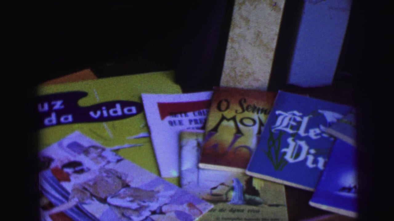 Portuguese-language magazines or books spread on a table in soft 8mm color.