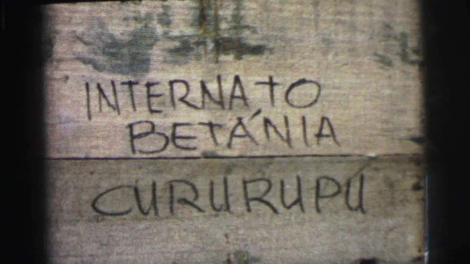 Close 8mm frame of a weathered wooden sign or crate marked by hand with Internato Betânia Cururupu.