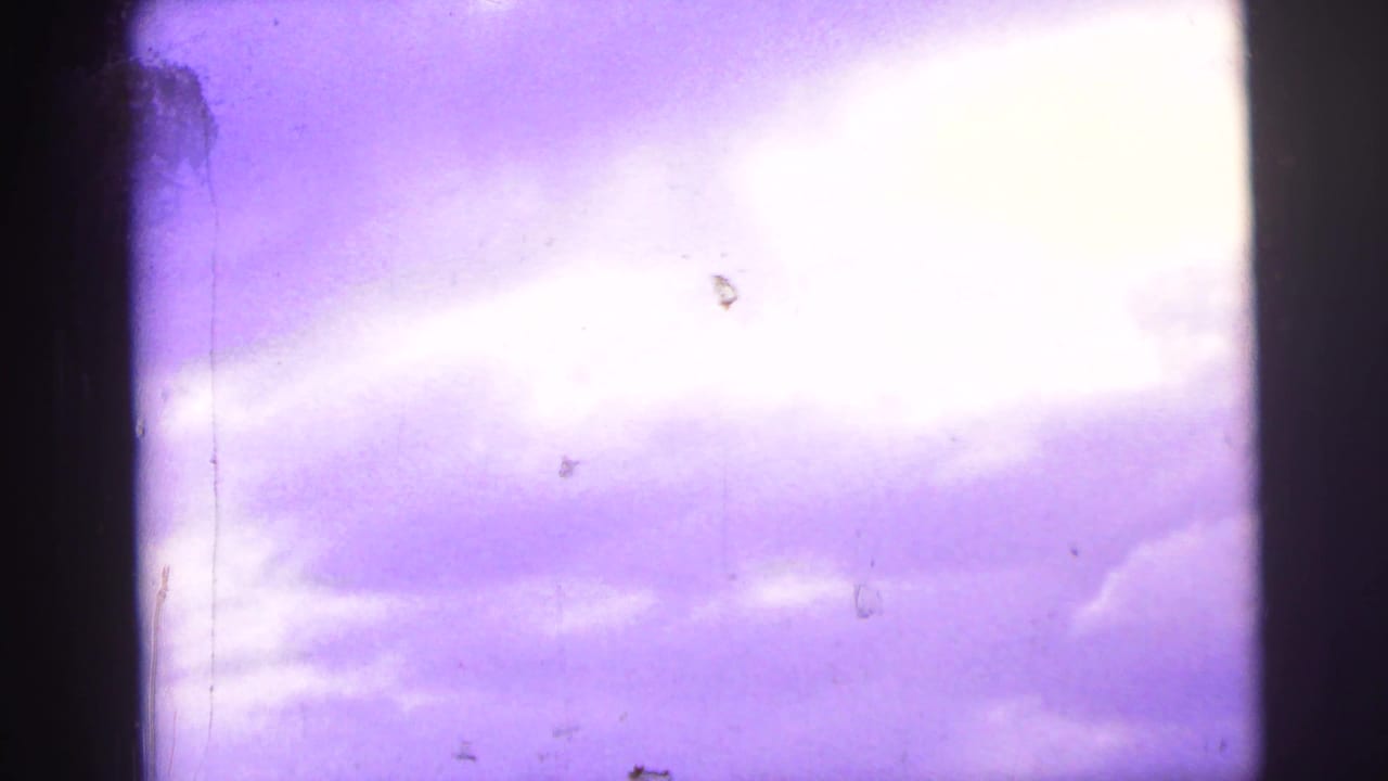 Purple-tinted sky and clouds seen through a dark framed division.