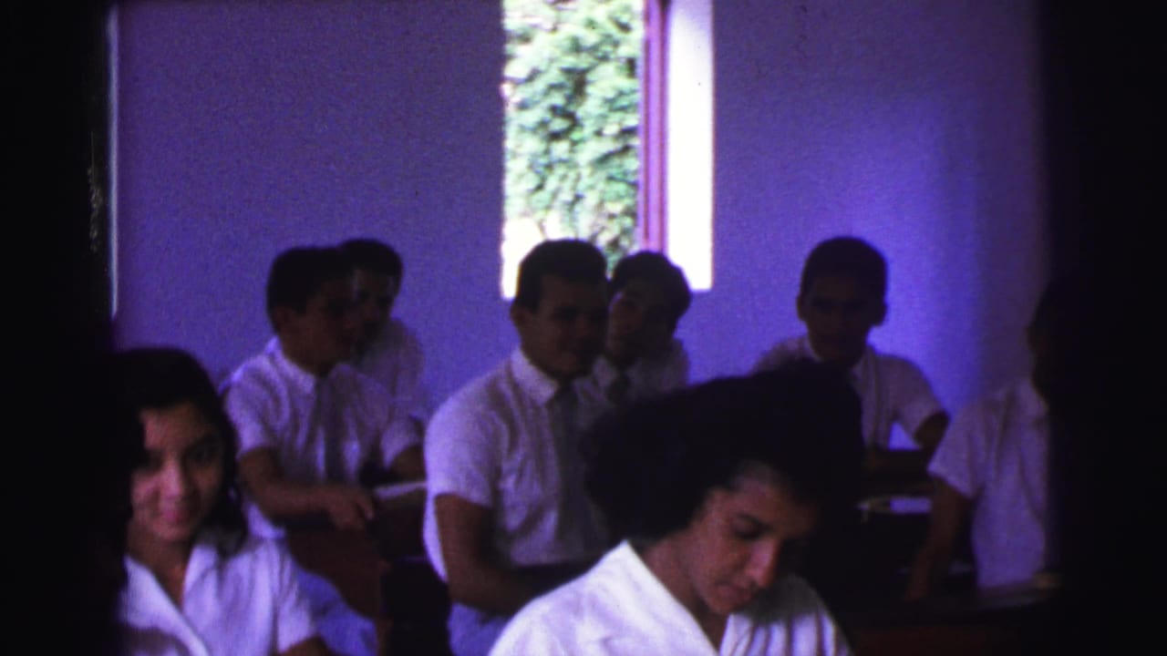 The classroom scene shows uniformed teenagers at desks in Brazil, with faces partly obscured by shadow and film grain.