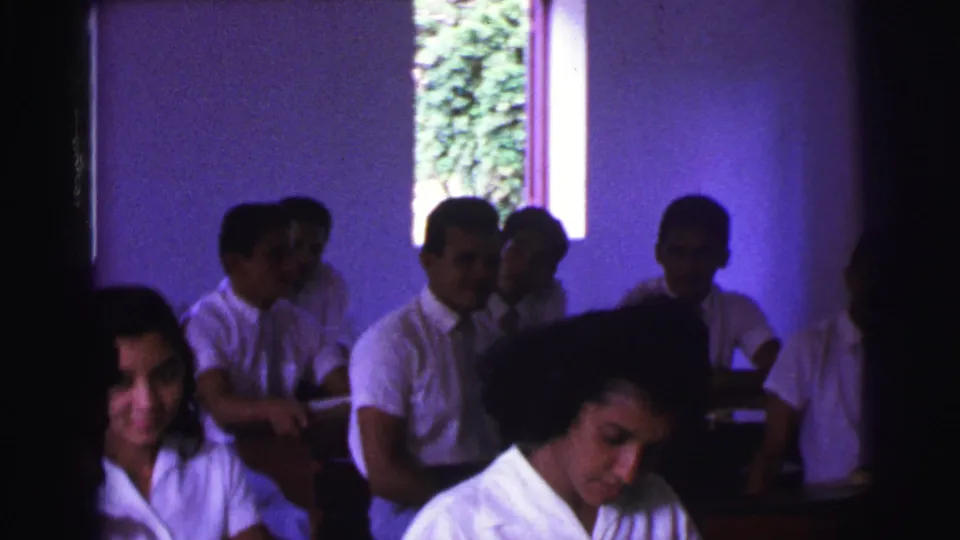 The classroom scene shows uniformed teenagers at desks in Brazil, with faces partly obscured by shadow and film grain.