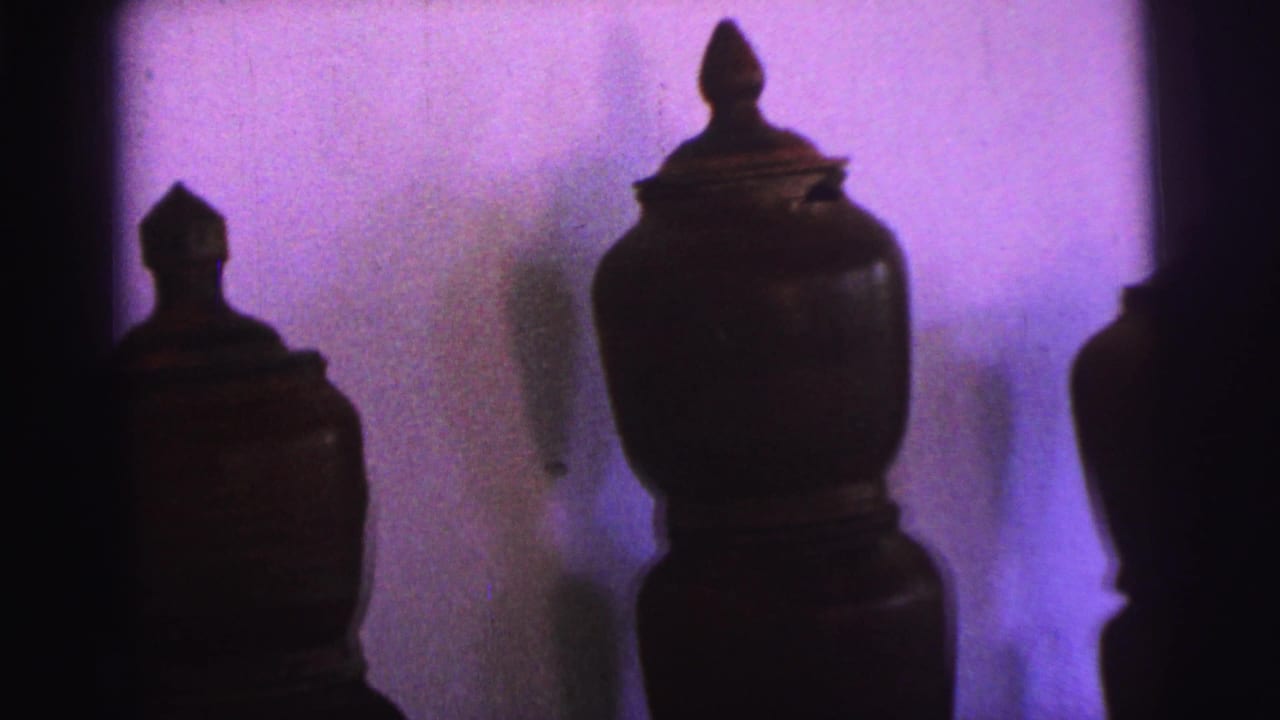 1967 Brazil 8mm frame showing a closer, slightly shifted view of lidded ceramic pots, including a larger vessel near center.