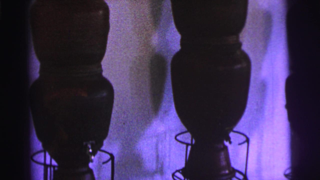 1967 Brazil 8mm frame showing the lower sections of dark museum vessels and their circular wire supports.