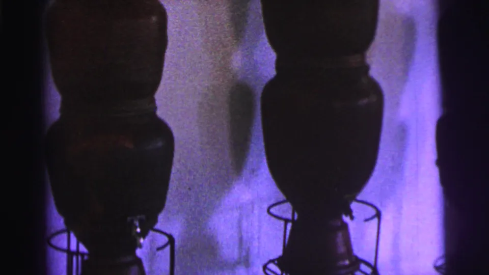 1967 Brazil 8mm frame showing the lower sections of dark museum vessels and their circular wire supports.