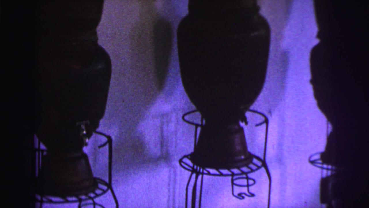 1967 Brazil museum frame showing dark vessel bases, metal wire supports, and shadowed purple lighting.