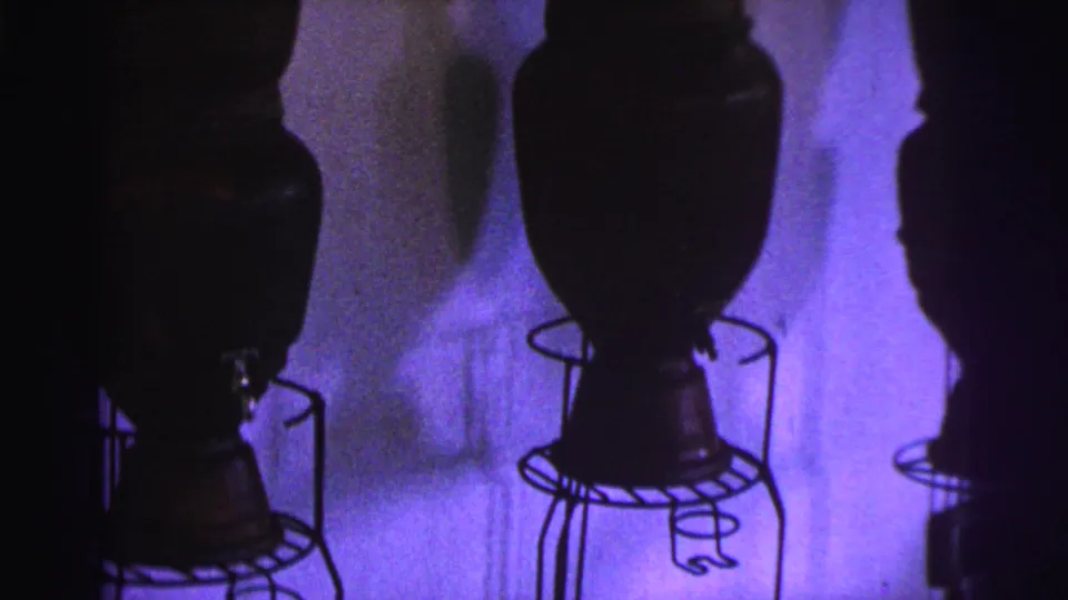 1967 Brazil museum frame showing dark vessel bases, metal wire supports, and shadowed purple lighting.