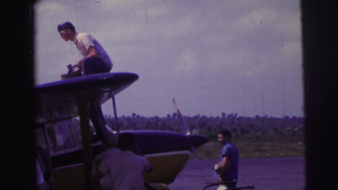 At a Brazilian airfield in 1967, one man climbs onto a small plane wing while another waits on the tarmac with a bag.
