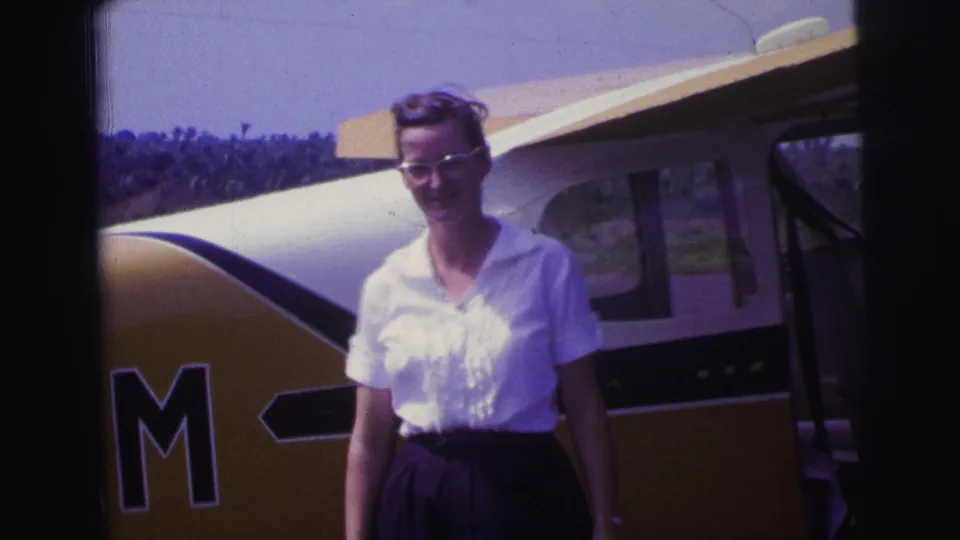 In the final frame, the woman stands beside the open aircraft door, with trees and sky behind the small plane.