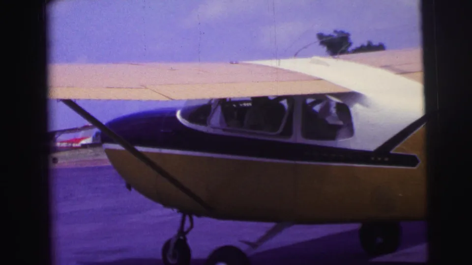 Side view of the yellow and blue aircraft in Brazil, with passengers or crew visible through the cockpit windows as it moves on the runway.