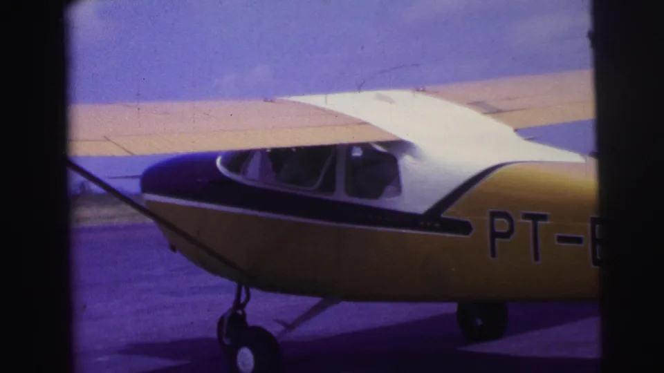 1967 Brazil frame showing the aircraft midsection, landing gear, wing strut, and partial PT-BLM registration on the yellow fuselage.