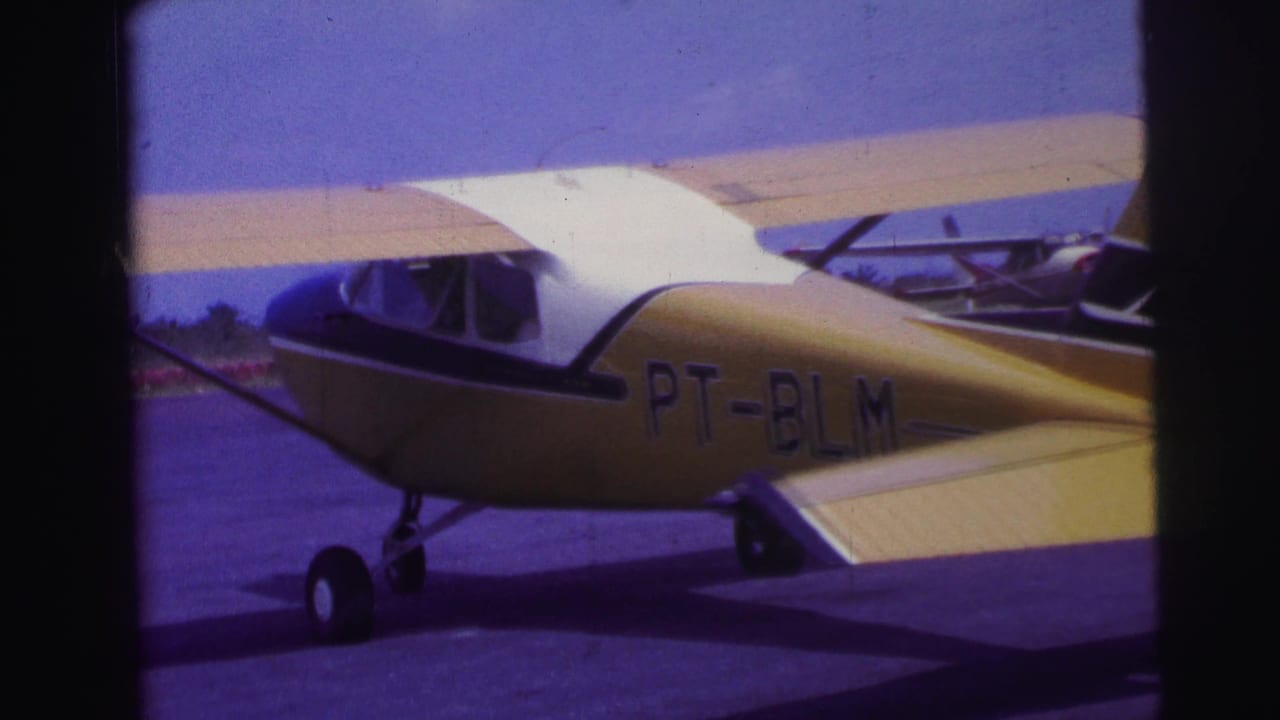 Yellow and white single-engine plane on a runway, seen from the side.