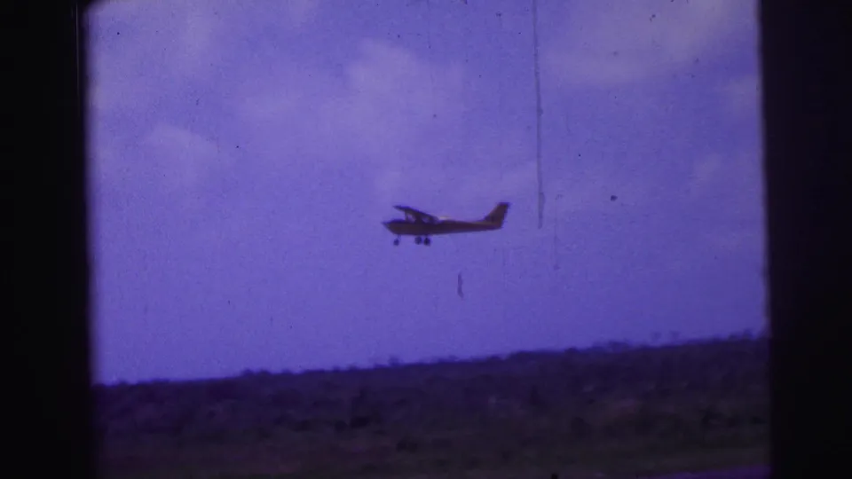Small single-engine plane continues its climb in a 1967 Brazil 8mm shot with visible film scratches.